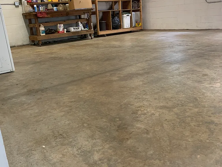 Large shop/storage area adjacent to garage with natural light.