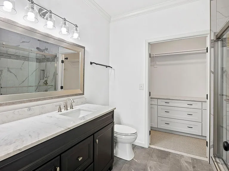 Main bathroom with walk-in closet, new cabinets, carpet and new clothes hanging rod