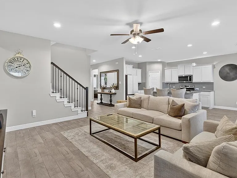 Open-concept living area with wood-finish flooring, recessed lighting, and a ceiling fan