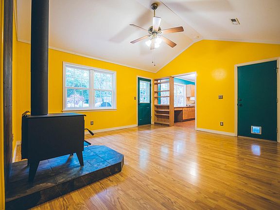 Living area with wood burning stove and vaulted ceiling