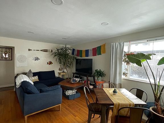 Large living area with recessed lighting has rooms for dining table sofa and more