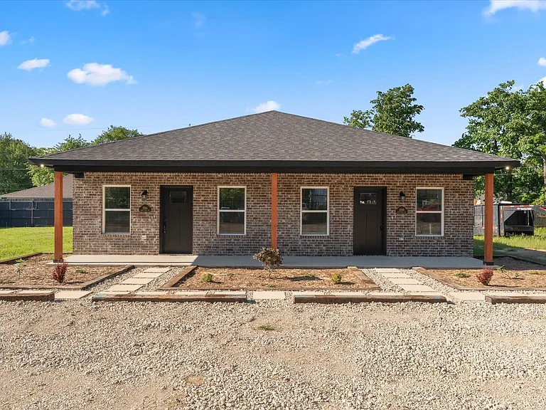 Contemporary duplex featuring brick facade, dark roofing, and covered front porches with wood posts