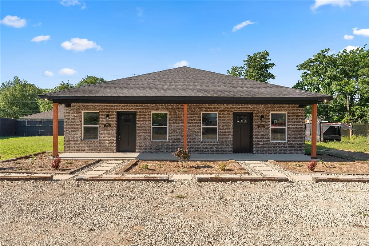 Contemporary duplex featuring brick facade, dark roofing, and covered front porches with wood posts - 109A Happy Hill Trl