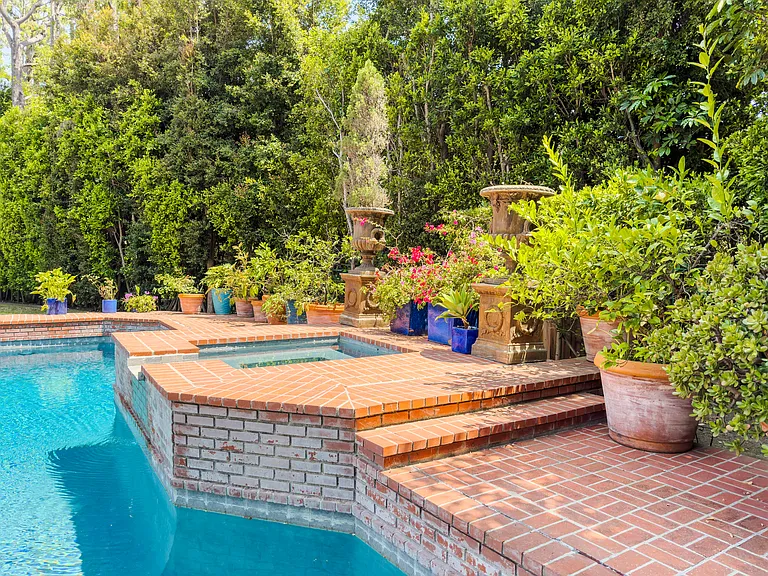 Raised spa with brick masonry and garden accents completes this backyard oasis at this Beverly Hills luxury rental, 1094 Garden Lane, 90210.