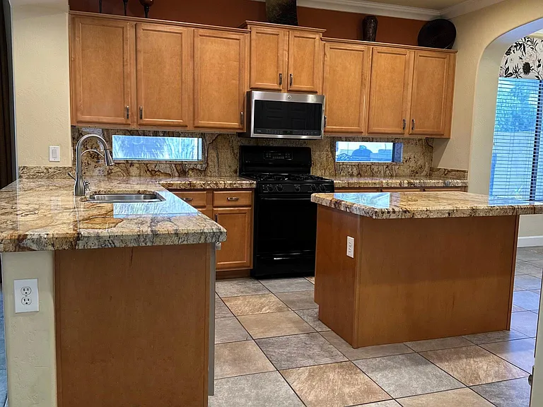 Kitchen with gas stove, breakfast island for additional seating and granite throughout