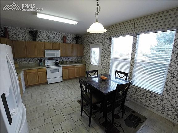 Large open kitchen with designer wallpaper, tile floor, and walk out to the back
