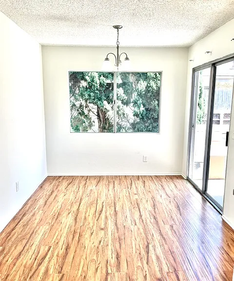 Dining room with previous floors in a similar unit with new dining chandelier