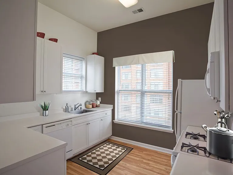Classic I kitchen with white appliances, white cabinetry, and hard surface flooring
