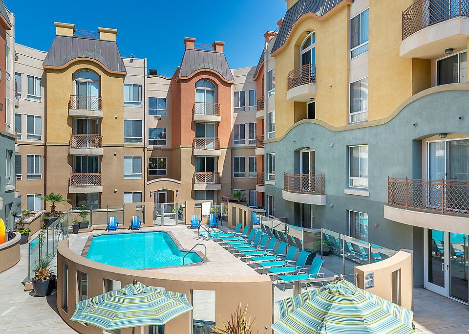 Swimming pool and spa surrounded by lounge chairs.
