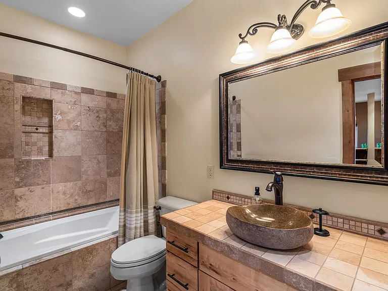 Guest bath with custom vessel sink and Montana Travertine tile.