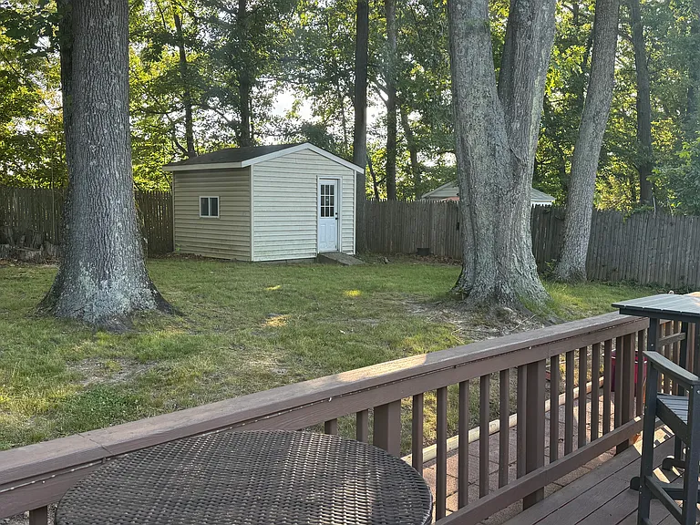 Behind the house on the patio looking away from the house, available shed