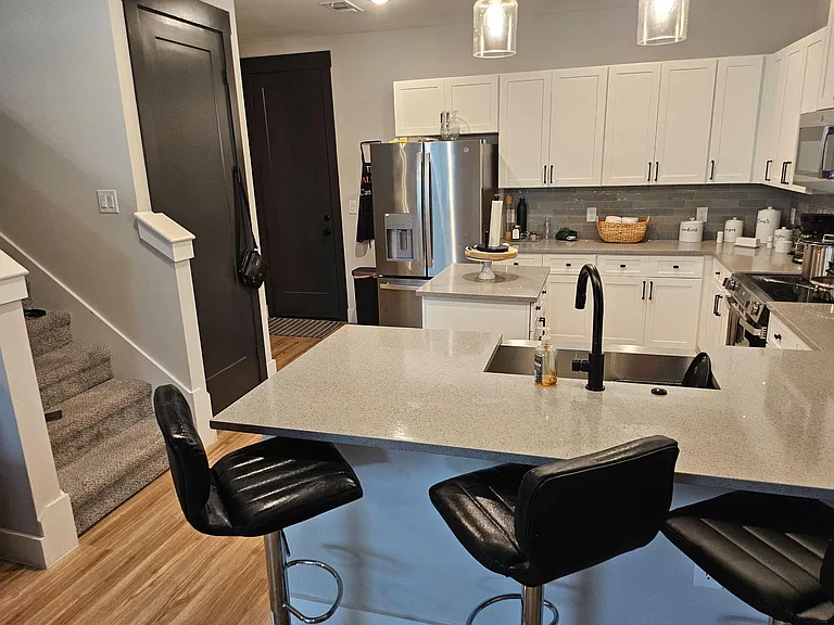 Spacious kitchen with a large island, bar seating, ample shaker cabinetry, and stainless-steel appliances for everyday cookin