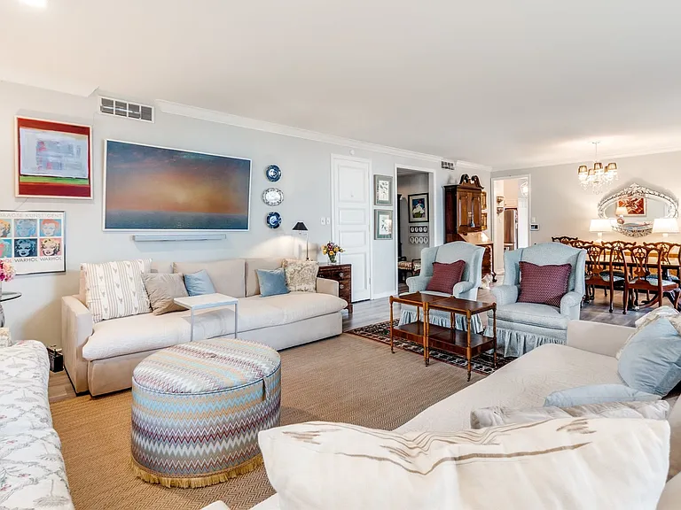 Spacious living area featuring light-toned wall finishes and crown molding