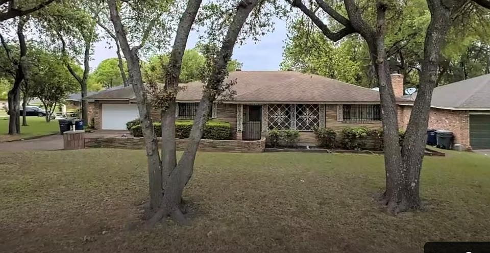 Ranch-style house featuring a front lawn and a garage