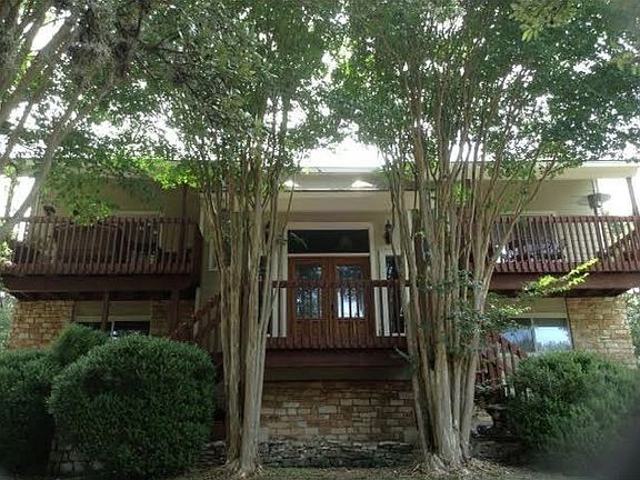 A shady yard surrounds this 4/3.5 in Westlake Hills, just mi