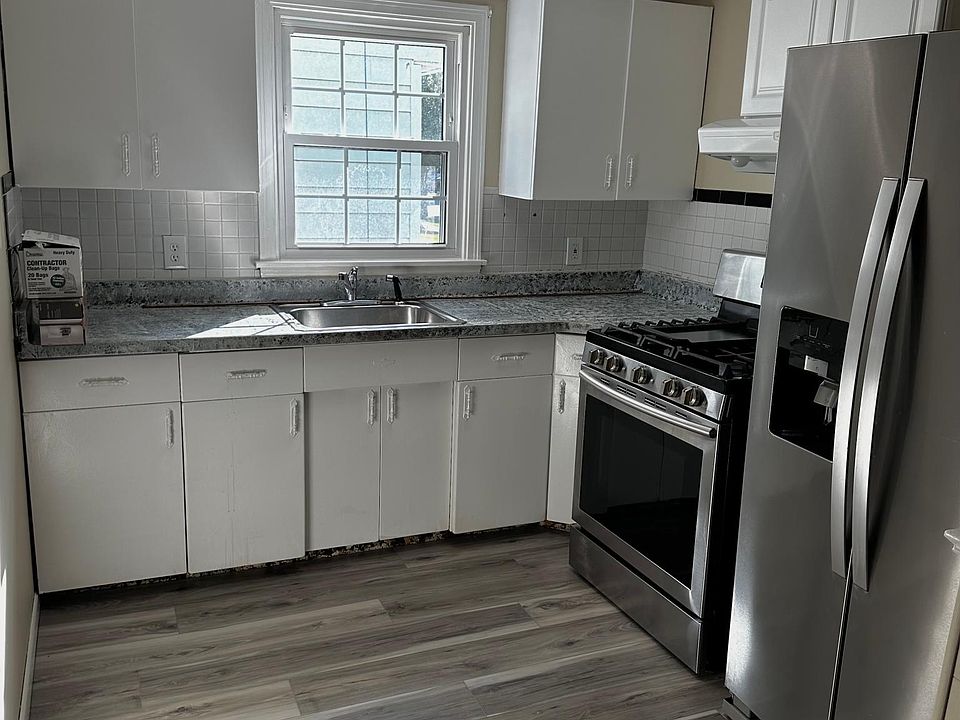 Kitchen with new appliances, brand new vinyl floors, and new modern light fixtures!