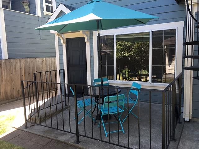 Front Door at Rear of Building / Living Room Windows / Adjacent Patio