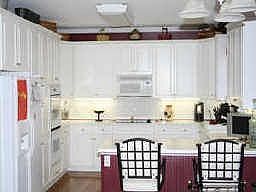 BRIGHT WHITE KITCHEN WITH HARD SURFACE COUNTER TOPS AND UNDER COUNTER LIGHTING