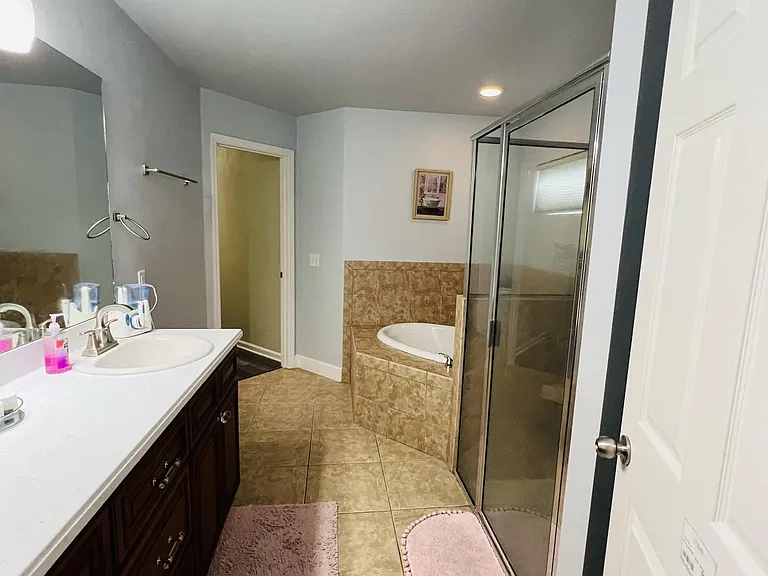 Attached to the master bedroom- a spacious bathroom that features a stunning drop-in bathtub , walk-in shower with modern fixtures