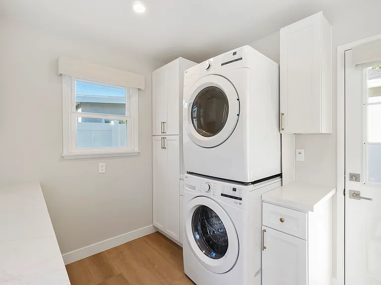 Large laundry room with additional storage and home office space with built in desk
