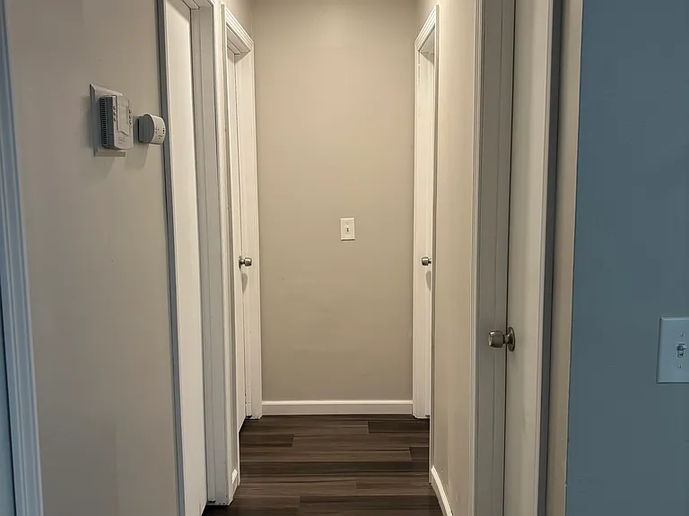 Central hallway connecting bathroom and 3 bedrooms. Attic access above.