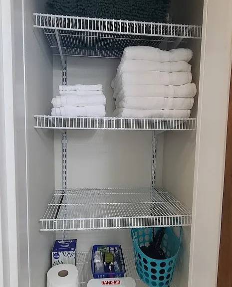 Bathroom closet with amenities, towels, and bath mats.