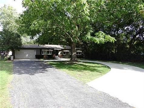 Front Of Home With Half Circle Drive & An Oversized 1 Car Garage