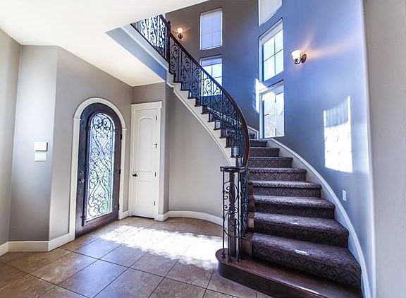 Foyer entry with extra lighting, tall ceilings, and open to the main living area.