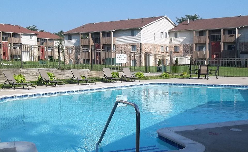 Brighton Cove sparkling outdoor swimming pool with lounge chairs and tables.