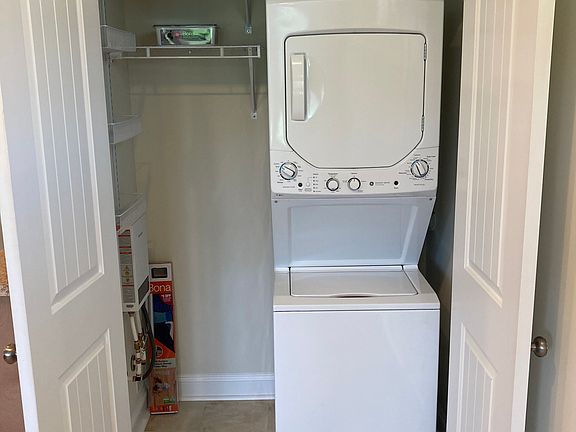 Stacked washer/dryer and coat closet.