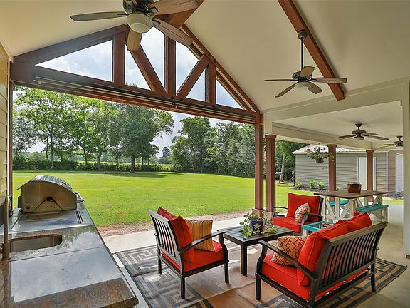 Stunning covered back porch with wood beams, vaulted ceiling and extended covered patio eating area.