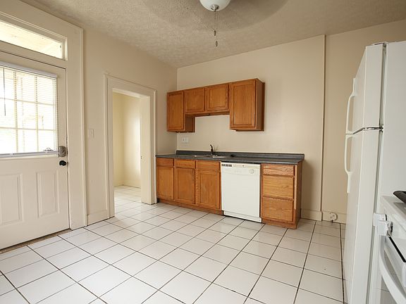 Kitchen with gas stove, dishwasher, sink with disposal. Back door to outside is on the left. A doorway to a small pantry is to the right of the back door.