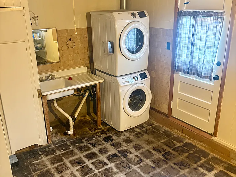 Washer and dryer and sink in converted garage.