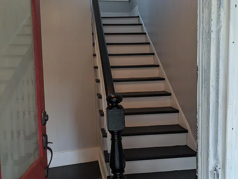 Freshly painted stairs and large entry space for bike storage.