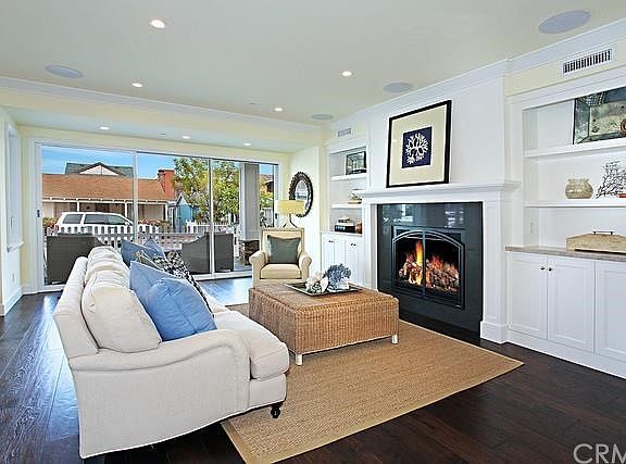 Great Room with fireplace and hickory floors opens to large front patio