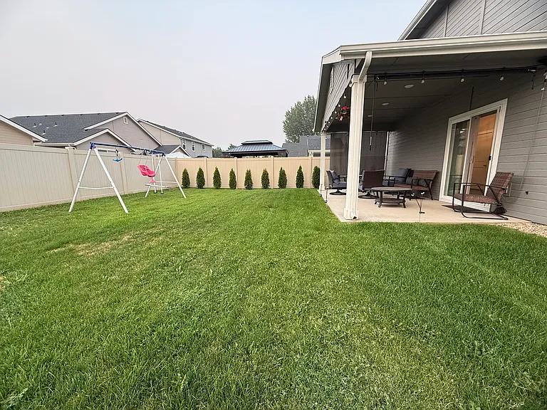 Fully fenced backyard with covered patio.