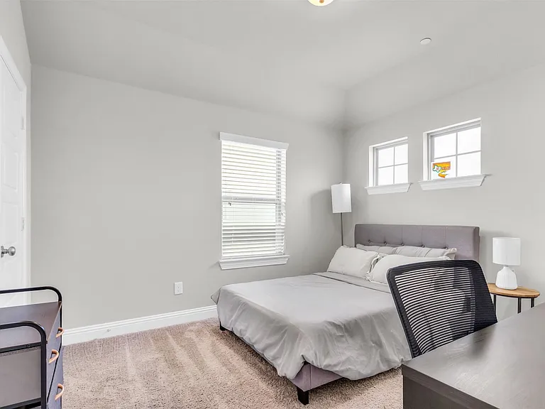 Carpeted room featuring light gray walls, white trim, and a high ceiling