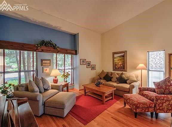 Living room with wood floors, large windows & open into the dining room