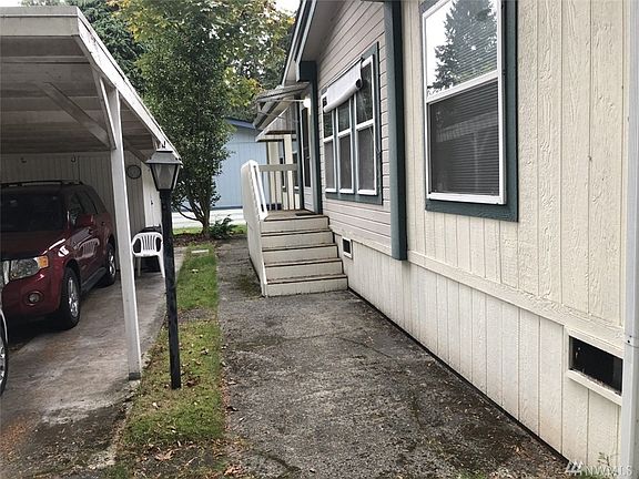 Convenient back deck entrance. A storage shed attached to carport for all your outdoor tools and toys. 