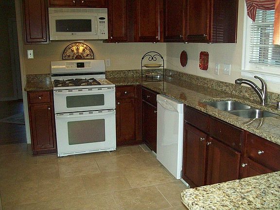 Renovated kitchen features travertine floors, granite counters, custom cabinets,and new fixtures.