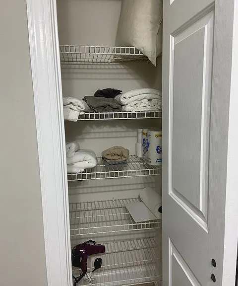 Private hall bath closet stocked with bath linens, offering extra storage.
