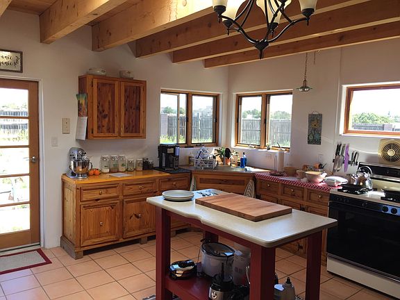 Country kitchen. Gas stove and locally carved cabinets. Windows look out to mountains and coyote fencing.
