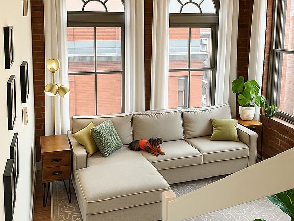 Double height living room with four large windows affording an abundance of natural light.