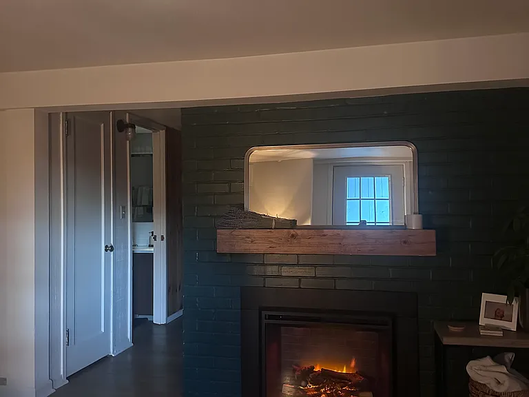Living room with included electric fireplace and mantel. Fireplace features multiple flame settings and provides supplemental heat.