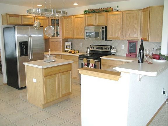 Open and bright kitchen with tiled backsplash, island and more! 