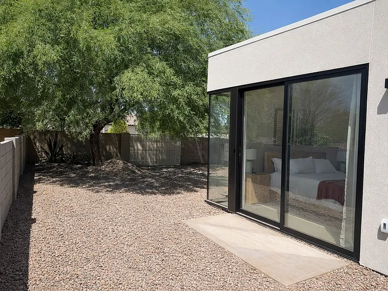 Private outdoor patio with sliding glass doors and desert landscaping for a tranquil retreat.