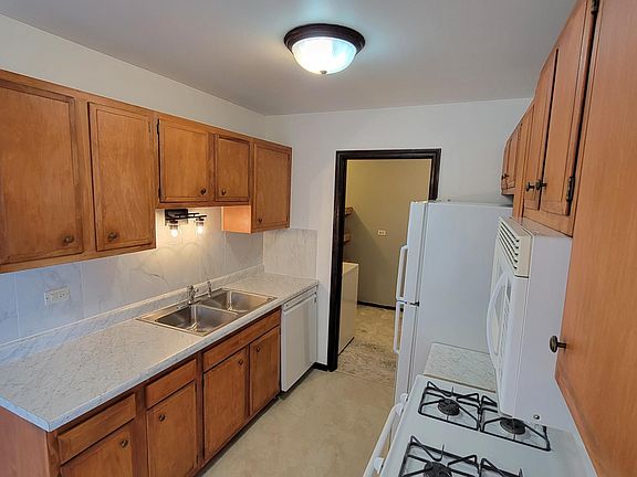 View of Galley Kitchen. New countertops, backsplash, sink, lighting, dishwasher. Like-new gas range/oven, microwave and refrigerator!