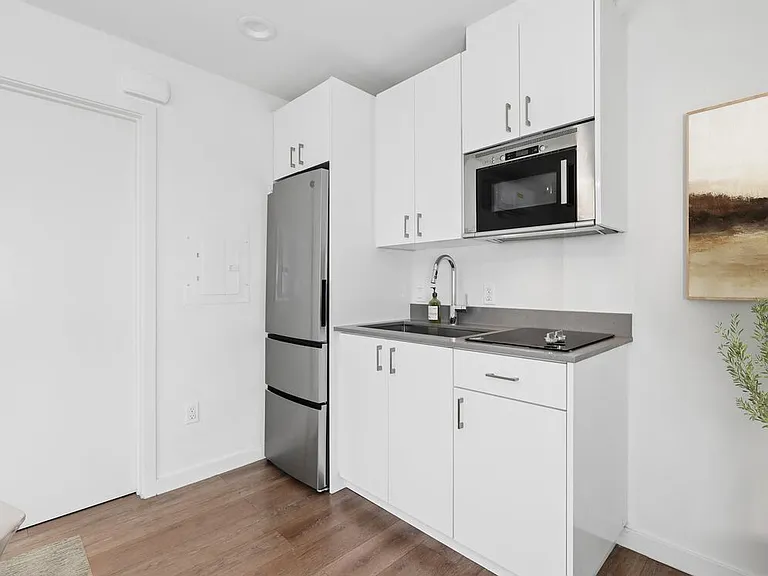 Classic Package II kitchen with white cabinetry, grey quartz countertops, stainless steel appliances, and hard surface flooring