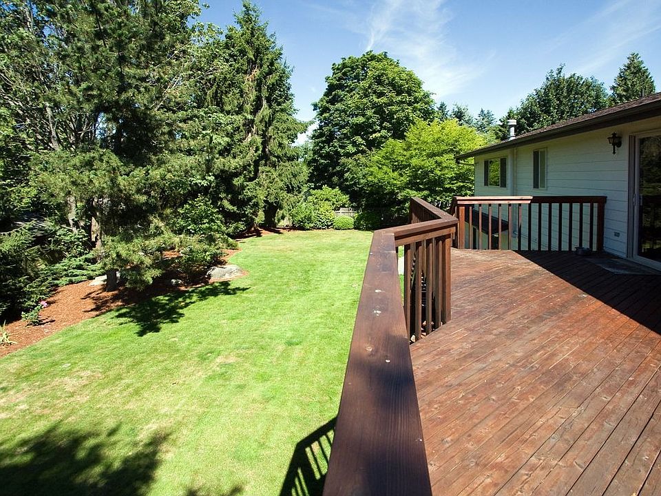 Large deck looks over expansive yard.