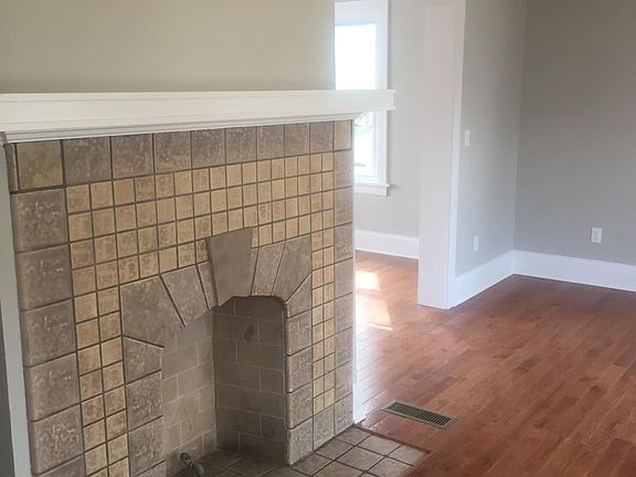 View of Living room from entry hall with beautifully restored, decorative fireplace